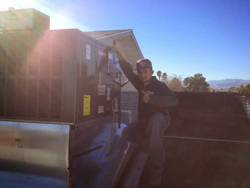 HVAC technician performing AC Tune-Up on a rooftop unit in Beltsville